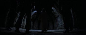 Movie still from “Star Trek V: The Final Frontier” (1989), directed by William Shatner – A man standing in the dark in front of a cave; Wide shot, Low angle