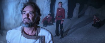 Movie still from “Star Trek V: The Final Frontier” (1989), directed by William Shatner – Two men dressed in star trek uniforms in a cave; Medium shot, Over the shoulder angle