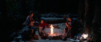 Movie still from “Star Trek V: The Final Frontier” (1989), directed by William Shatner – A group of people sitting around a fire; Wide shot, High angle