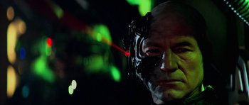 Movie still from “Star Trek: First Contact” (1996), directed by Jonathan Frakes – A man's face with a laser beam coming out of his eye; Close Up shot, Low angle