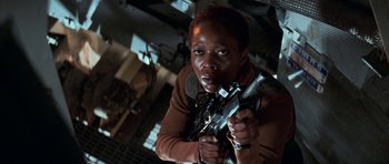 Movie still from “Star Trek: First Contact” (1996), directed by Jonathan Frakes – A person holding a gun in a room; Close Up shot, Low angle