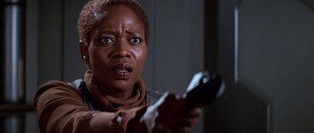 Movie still from “Star Trek: First Contact” (1996), directed by Jonathan Frakes – A woman holding a remote control in her hand; Close Up shot, Low angle