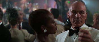 Movie still from “Star Trek: First Contact” (1996), directed by Jonathan Frakes – A man and a woman are standing in front of a group of people; Close Up shot, Over the shoulder angle