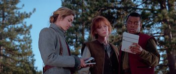 Movie still from “Star Trek: First Contact” (1996), directed by Jonathan Frakes – Two women standing next to each other holding cell phones in their hands; Medium shot, Low angle