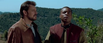 Movie still from “Star Trek: First Contact” (1996), directed by Jonathan Frakes – Two men standing next to each other near a forest; Close Up shot, Low angle