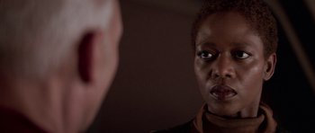 Movie still from “Star Trek: First Contact” (1996), directed by Jonathan Frakes – A woman looking into a mirror while standing next to a man; Close Up shot, Over the shoulder angle