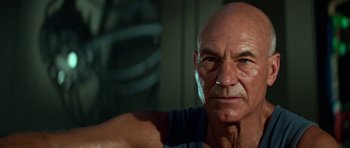 Movie still from “Star Trek: First Contact” (1996), directed by Jonathan Frakes – An older man with a shaved head is looking at the camera; Close Up shot, Low angle