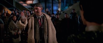 Movie still from “Star Trek: First Contact” (1996), directed by Jonathan Frakes – A group of people standing around a man in a fur coat; Medium shot, Over the shoulder angle