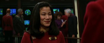 Movie still from “Star Trek: Generations” (1994), directed by David Carson – A woman in a red dress smiling for the camera; Close Up shot, Over the shoulder angle