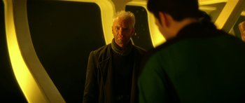 Movie still from “Star Trek: Generations” (1994), directed by David Carson – A man looking into a mirror while standing next to another man; Close Up shot, Over the shoulder angle