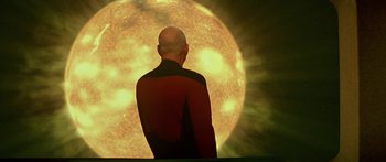 Movie still from “Star Trek: Generations” (1994), directed by David Carson – A man standing in front of a large sun; Medium shot, Low angle