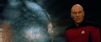 Movie still from “Star Trek: Generations” (1994), directed by David Carson – A man standing in front of an image of a planet; Close Up shot, Low angle