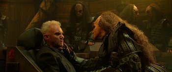 Movie still from “Star Trek: Generations” (1994), directed by David Carson – A man with a bunch of makeup on his face and another man with a bunch of makeup on his face and another man with a bunch of makeup; Medium shot, Over the shoulder angle