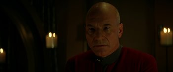 Movie still from “Star Trek: Generations” (1994), directed by David Carson – A man with a bald head wearing a red and black shirt; Close Up shot, Over the shoulder angle