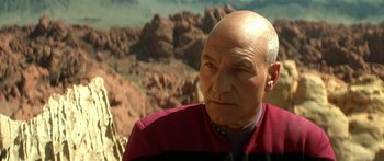 Movie still from “Star Trek: Generations” (1994), directed by David Carson – An older man wearing a red and black shirt; Close Up shot, Over the shoulder angle