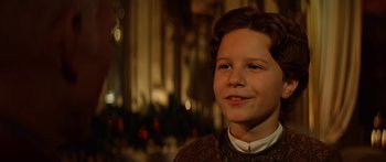 Movie still from “Star Trek: Generations” (1994), directed by David Carson – A young boy smiling for the camera in front of a christmas tree; Close Up shot, Over the shoulder angle