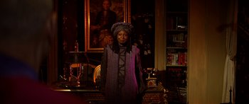 Movie still from “Star Trek: Generations” (1994), directed by David Carson – A woman standing in front of a painting in a living room; Medium shot, Over the shoulder angle