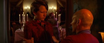 Movie still from “Star Trek: Generations” (1994), directed by David Carson – A young boy wearing a red shirt and a red bow tie; Medium shot, Over the shoulder angle
