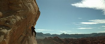 Movie still from “Star Trek: Generations” (1994), directed by David Carson – A man climbing up a rock wall in the mountains; Extreme Wide shot, Low angle