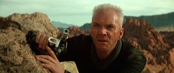 Movie still from “Star Trek: Generations” (1994), directed by David Carson – A man holding a gun while standing on top of a hill; Close Up shot, Low angle