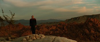 Movie still from “Star Trek: Generations” (1994), directed by David Carson – A man standing on top of a mountain near rocks; Extreme Wide shot, Low angle
