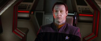 Movie still from “Star Trek: Insurrection” (1998), directed by Jonathan Frakes – A man in a star trek uniform looking at the camera; Close Up shot, Over the shoulder angle