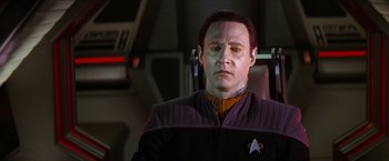 Movie still from “Star Trek: Insurrection” (1998), directed by Jonathan Frakes – A man in a purple and yellow uniform; Close Up shot, Over the shoulder angle