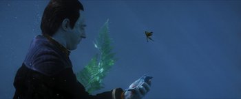Movie still from “Star Trek: Insurrection” (1998), directed by Jonathan Frakes – A man looking at his cell phone in front of an underwater plant; Close Up shot, High angle