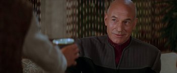 Movie still from “Star Trek: Insurrection” (1998), directed by Jonathan Frakes – An older man is holding a glass of wine; Close Up shot, Over the shoulder angle