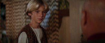 Movie still from “Star Trek: Insurrection” (1998), directed by Jonathan Frakes – A young boy with blonde hair and a white shirt; Close Up shot, Over the shoulder angle