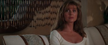 Movie still from “Star Trek: Insurrection” (1998), directed by Jonathan Frakes – A woman sitting on top of a couch in a room; Close Up shot, Over the shoulder angle