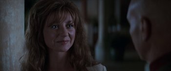 Movie still from “Star Trek: Insurrection” (1998), directed by Jonathan Frakes – A person smiling at the camera; Close Up shot, Over the shoulder angle