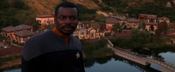 Movie still from “Star Trek: Insurrection” (1998), directed by Jonathan Frakes – A man standing next to a body of water; Close Up shot, Over the shoulder angle