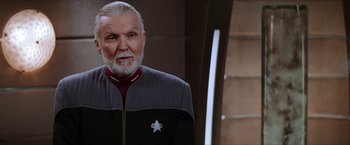 Movie still from “Star Trek: Insurrection” (1998), directed by Jonathan Frakes – An older man with a gray beard wearing a uniform; Close Up shot, Over the shoulder angle