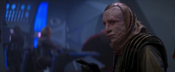 Movie still from “Star Trek: Insurrection” (1998), directed by Jonathan Frakes – A man with a face mask on holding a cell phone; Close Up shot, Low angle