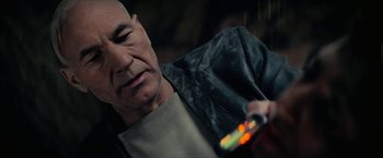 Movie still from “Star Trek: Insurrection” (1998), directed by Jonathan Frakes – An older man looking at a cell phone; Close Up shot, Over the shoulder angle