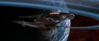 Movie still from “Star Trek: Insurrection” (1998), directed by Jonathan Frakes – An image of a space ship flying over the earth; Extreme Wide shot, Overhead angle