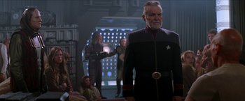 Movie still from “Star Trek: Insurrection” (1998), directed by Jonathan Frakes – A group of people standing in a room; Medium shot, Over the shoulder angle