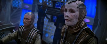 Movie still from “Star Trek: Insurrection” (1998), directed by Jonathan Frakes – A group of people standing next to each other on a stage; Medium shot, Over the shoulder angle