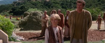Movie still from “Star Trek: Insurrection” (1998), directed by Jonathan Frakes – A group of people standing around a young boy; Medium shot, Over the shoulder angle