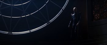 Movie still from “Star Trek: Nemesis” (2002), directed by Stuart Baird – A man standing in front of a large metal object; Wide shot, Low angle
