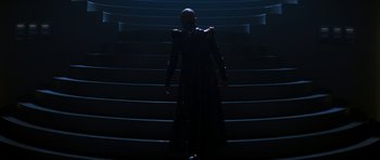 Movie still from “Star Trek: Nemesis” (2002), directed by Stuart Baird – A woman in a black dress standing on some stairs; Wide shot, Low angle