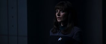 Movie still from “Star Trek: Nemesis” (2002), directed by Stuart Baird – A woman with long brown hair wearing a star trek uniform; Close Up shot, Low angle
