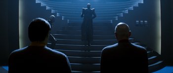Movie still from “Star Trek: Nemesis” (2002), directed by Stuart Baird – A man standing on top of a set of stairs; Wide shot, Over the shoulder angle