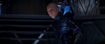 Movie still from “Star Trek: Nemesis” (2002), directed by Stuart Baird – A bald man in a blue leather jacket; Medium shot, Over the shoulder angle