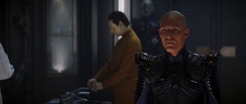 Movie still from “Star Trek: Nemesis” (2002), directed by Stuart Baird – A man in a black suit and a man in a brown jacket; Medium shot, Over the shoulder angle