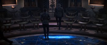 Movie still from “Star Trek: Nemesis” (2002), directed by Stuart Baird – Two people are standing in front of a circle of chairs; Wide shot, High angle