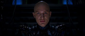 Movie still from “Star Trek: Nemesis” (2002), directed by Stuart Baird – A man with a bald head wearing a black suit; Close Up shot, Low angle