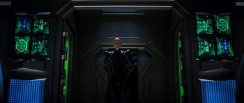 Movie still from “Star Trek: Nemesis” (2002), directed by Stuart Baird – A man in a black suit standing in front of a wall; Wide shot, Low angle