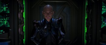 Movie still from “Star Trek: Nemesis” (2002), directed by Stuart Baird – A bald man in a black and blue outfit; Medium shot, Low angle